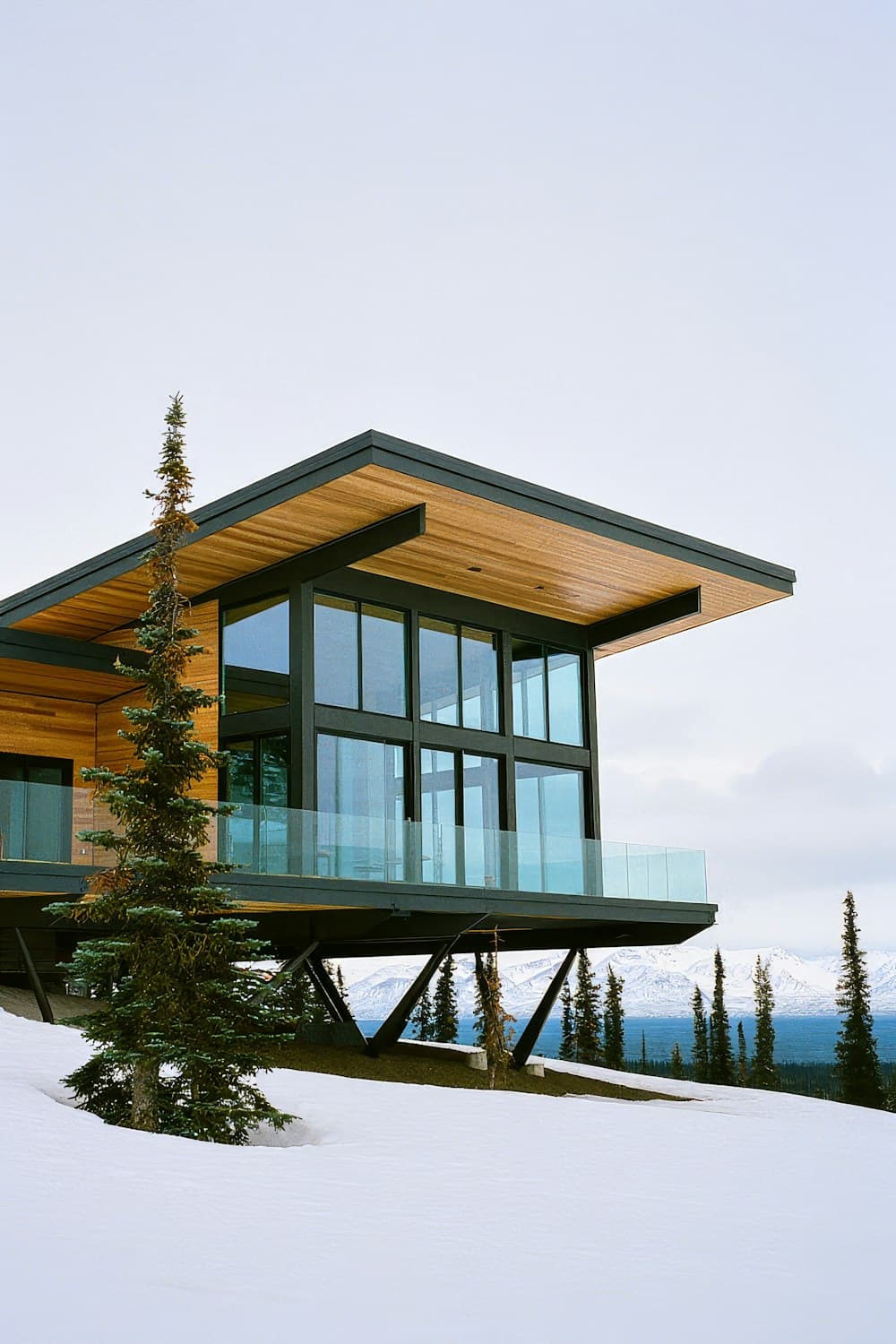 Modern house with a timber facade and large glass surfaces in a mountain landscape