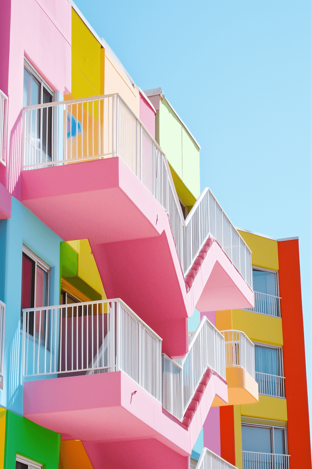 Residential building with colourful balconies against a blue sky